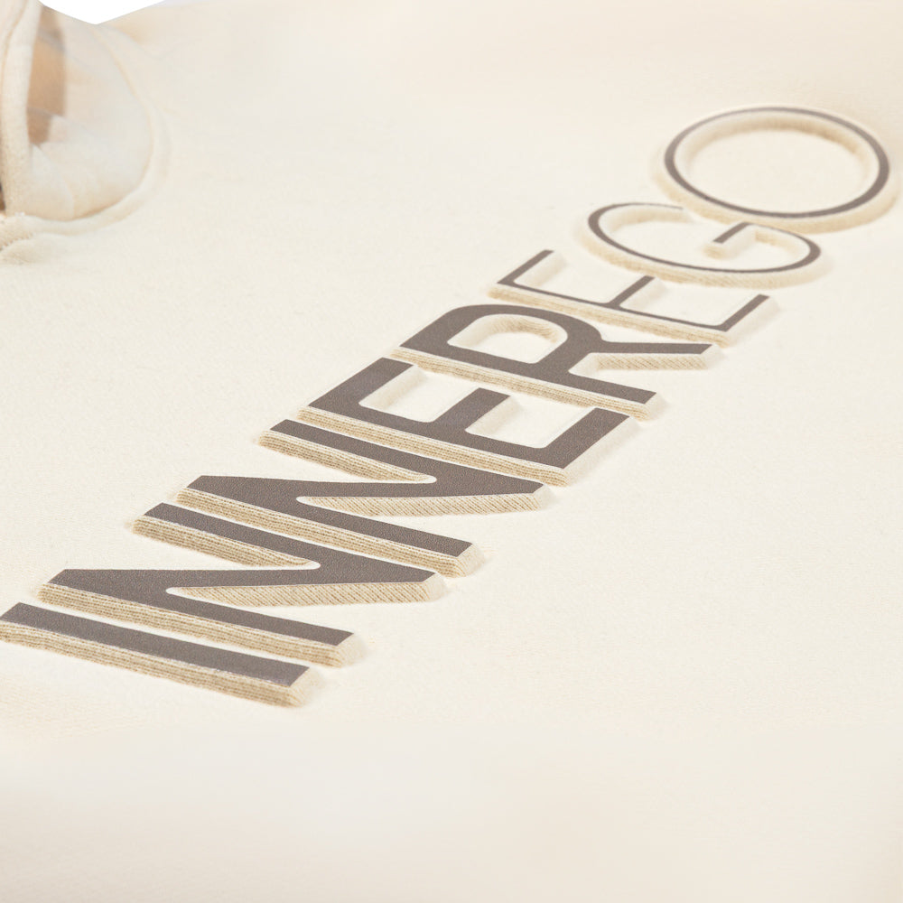 close-up embossed INNER EGO logo on cream hoodie